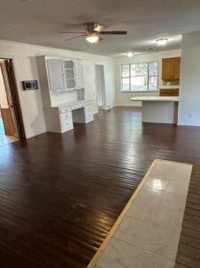 Unfurnished living room with a ceiling fan and wood finished floors | Image 13