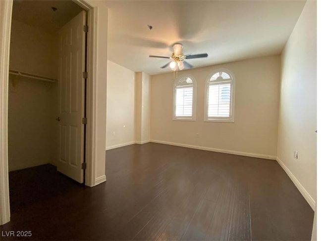 Unfurnished bedroom featuring dark wood-style flooring and a ceiling fan | Image 8