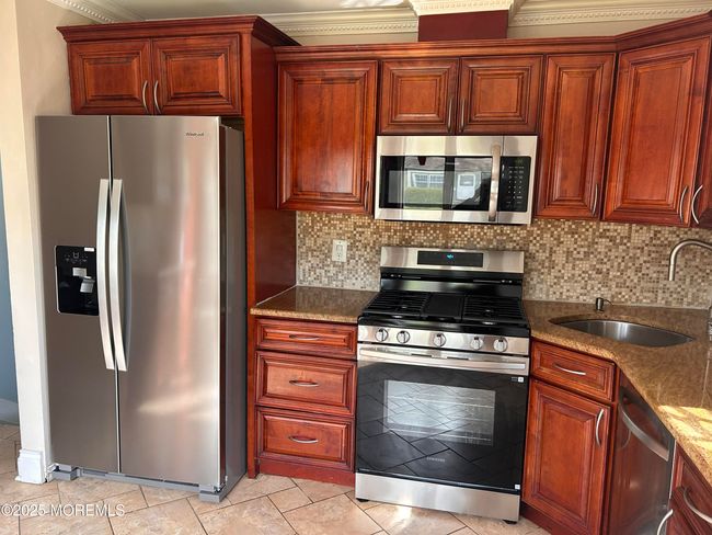 Eat-in-Kitchen with Granite Counters, Tiled Back Splash, Microwave, Tiled Floor. Refrigerator & Gas Stove 04/2025. | Image 4