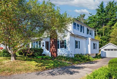 View of front of house featuring an outdoor structure, a garage, and a front yard | Image 2