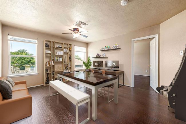 This versatile upstairs game room offers endless possibilities, perfect as a media room, home office, study space, or creative play area. Featuring large windows for natural light, rich wood-style flooring, and ample room to customize to fit your lifestyle. *Virtually Staged | Image 11