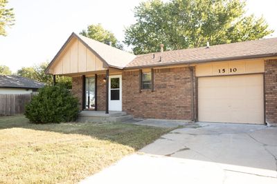 Ranch-style home with a garage and a front lawn | Image 1