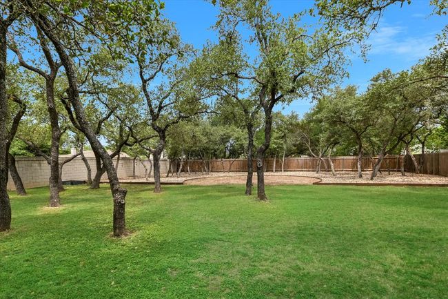 The expansive backyard is home to mature and meticulously maintained Oak trees, providing lovely shade on those long summer days. | Image 16