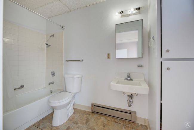 Full bathroom with shower / bathtub combination, toilet, a sink, a baseboard radiator, and baseboards | Image 11