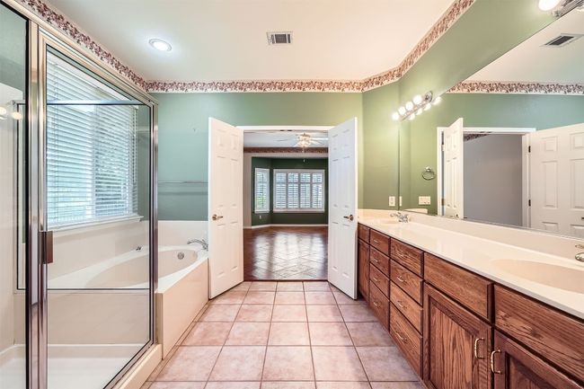Bathroom featuring a garden tub, double vanity, a ceiling fan, tile patterned floors, and a shower stall | Image 17