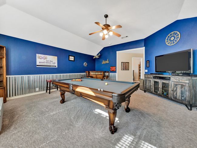Recreation game room with designer chair rail, lofted ceiling, ceiling fan, room for a billiard table, visible vents, and carpet | Image 38