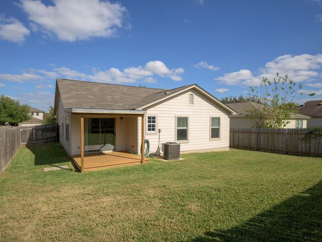 Back of house, wooden deck with a fenced backyard. | Image 25