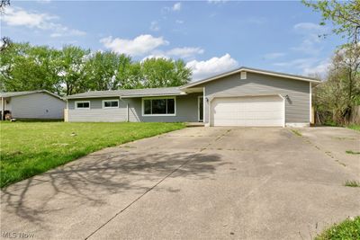 Ranch-style house with a garage and a front yard | Image 1