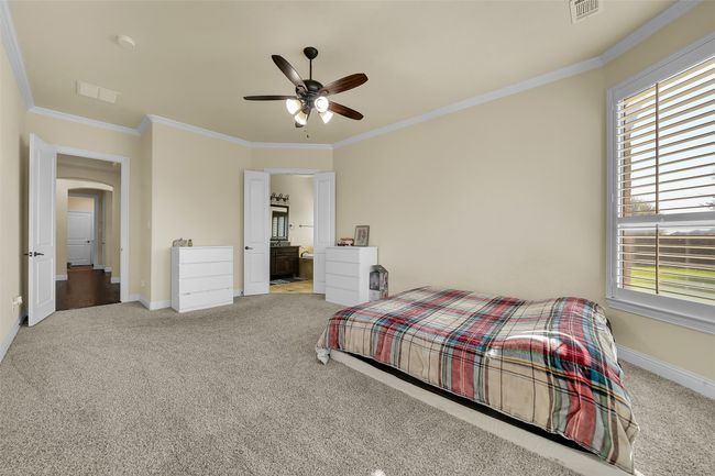 Bedroom featuring crown molding, carpet flooring, ensuite bath, and arched walkways | Image 18