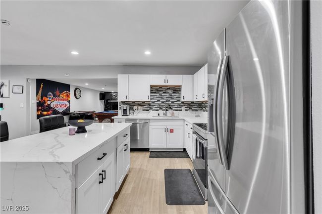 Kitchen featuring white cabinets, a sink, stainless steel appliances, recessed lighting, and light wood finished floors | Image 10