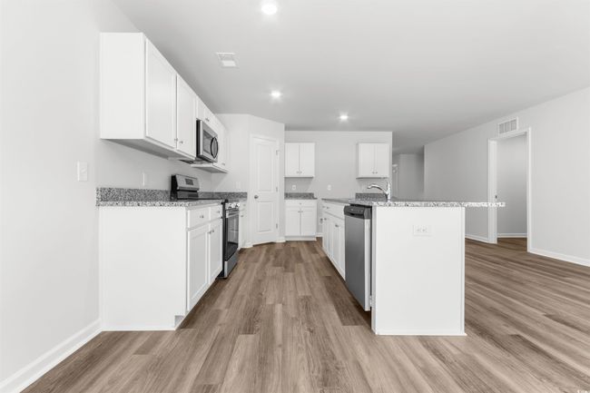 Kitchen with light hardwood / wood-style flooring, a center island with sink, sink, white cabinetry, and appliances with stainless steel finishes | Image 18
