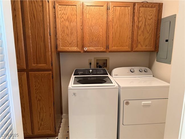 Laundry room featuring electric panel, washer and dryer, and cabinet space | Image 14