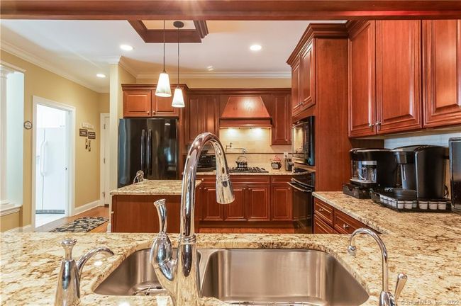 The kitchen has a Viking stove top, with a decorative range hood, Bosch dishwasher, built-in electric oven and a microwave oven above. | Image 6
