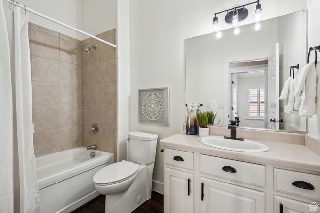 Full bathroom featuring shower / bathtub combination with curtain, vanity, and toilet | Image 22
