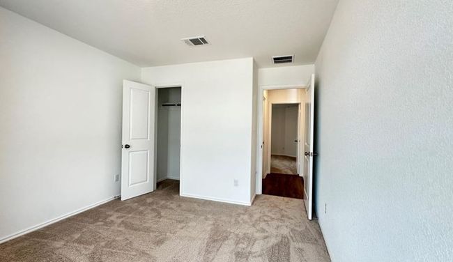 Unfurnished bedroom with carpet flooring and a closet | Image 10
