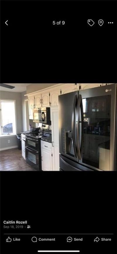 Kitchen featuring refrigerator with ice dispenser, black range with electric cooktop, dark hardwood / wood-style flooring, and white cabinets | Image 3