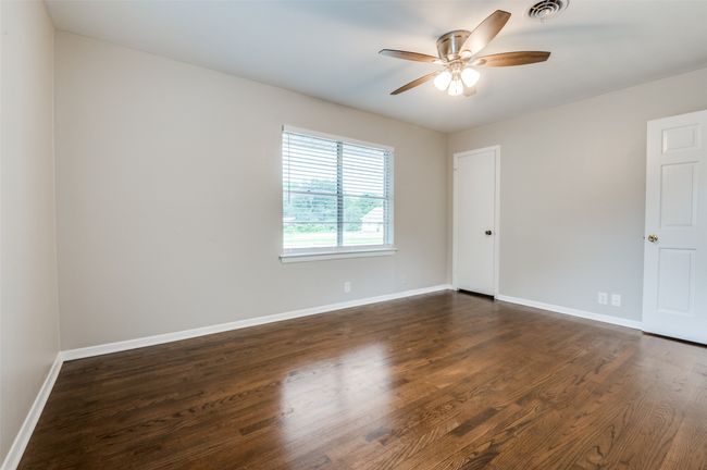 Bedroom featuring ceiling fan, baseboards, and dark real wood flooring | Image 19