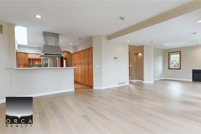 Unfurnished living room featuring light wood-style flooring, recessed lighting, and arched walkways | Image 15