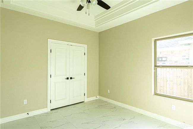 Unfurnished bedroom with marble finish floor, multiple windows, and baseboards | Image 22