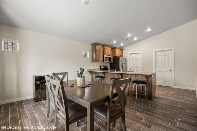 Dining room featuring baseboards, wood finish floors, lofted ceiling, and recessed lighting | Image 25