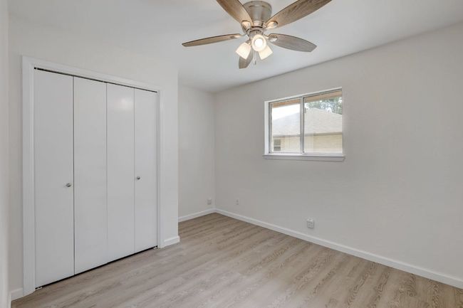 Unfurnished bedroom featuring light wood finished floors, a closet, baseboards, and a ceiling fan | Image 17