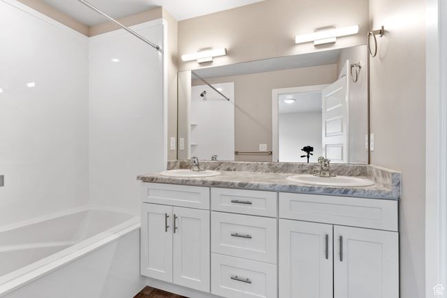 Bathroom featuring double vanity, shower combination, and a sink | Image 8
