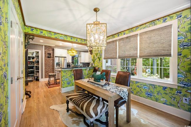 Dining space featuring ornamental molding, a chandelier, light wood-style floors, and wallpapered walls | Image 24