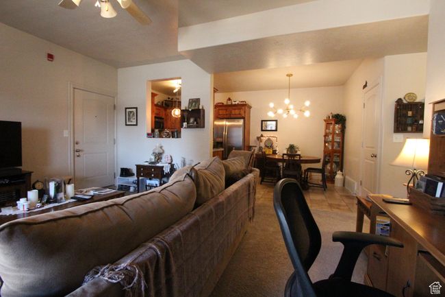 Living room featuring light colored carpet and ceiling fan with notable chandelier | Image 5