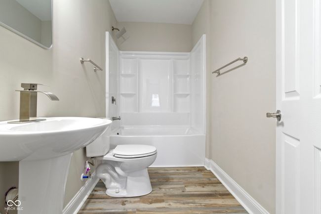 bathroom with wood finished floors, toilet, bathing tub / shower combination, and baseboards | Image 34