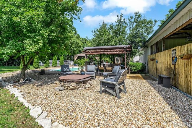 View of yard with a gazebo, an outdoor living space with a fire pit, and a patio | Image 23
