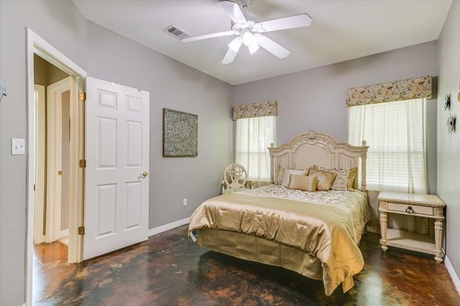 Bedroom with finished concrete floors, baseboards, and ceiling fan | Image 21