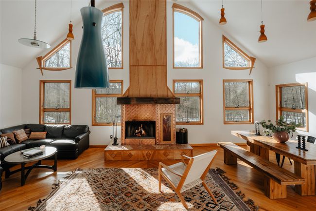 Living room with hardwood / wood-style flooring, a fireplace, high vaulted ceiling, and a healthy amount of sunlight | Image 6