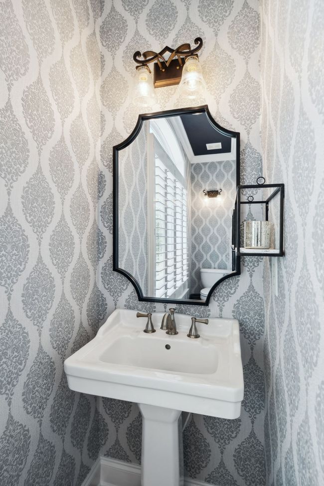 Elegant wallpaper and stylish fixtures elevate this main-level half bath. | Image 16