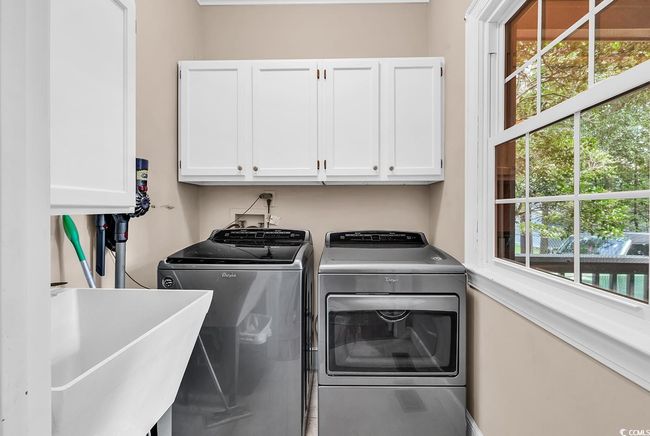 Laundry area featuring cabinet space and separate washer and dryer | Image 16