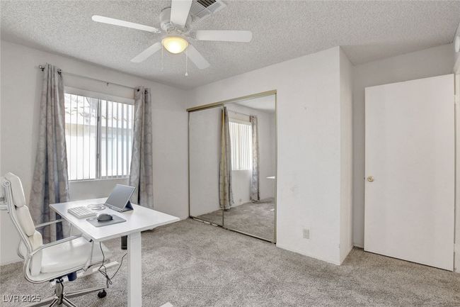 Carpeted office space with a ceiling fan, plenty of natural light, and a textured ceiling | Image 24