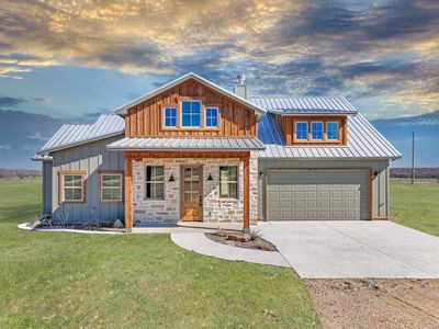 View of front of house with a garage and a lawn | Image 1