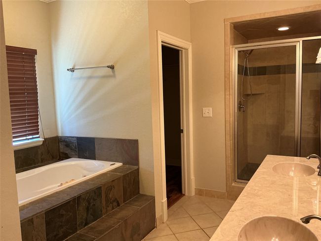 Bathroom featuring a shower stall, tile patterned floors, and a sink | Image 14
