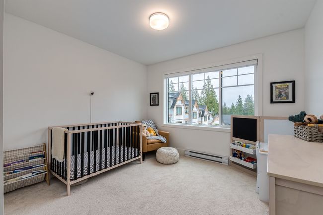 Carpeted bedroom with a baseboard radiator and a nursery area | Image 13