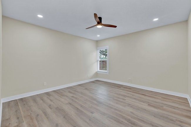 Empty room featuring baseboards, recessed lighting, wood finished floors, and a ceiling fan | Image 13