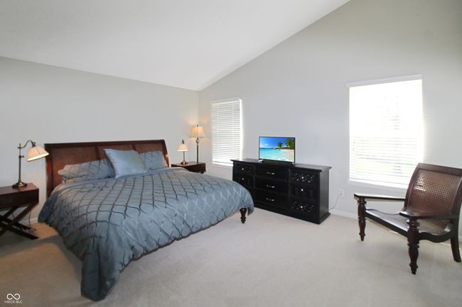 Enjoy a light and airy primary bedroom with double windows, soaring vaulted ceilings, and the ease of an attached private bath. | Image 11