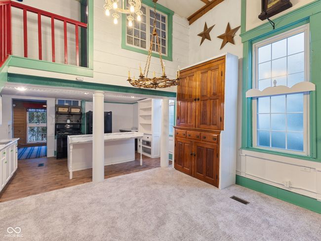 interior space with carpet flooring, visible vents, decorative columns, gas stove, and fridge | Image 14