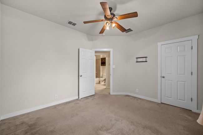 Unfurnished bedroom featuring light carpet, baseboards, and ensuite bath | Image 22