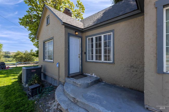 Doorway to property with stucco siding, roof with shingles, and a chimney | Image 4