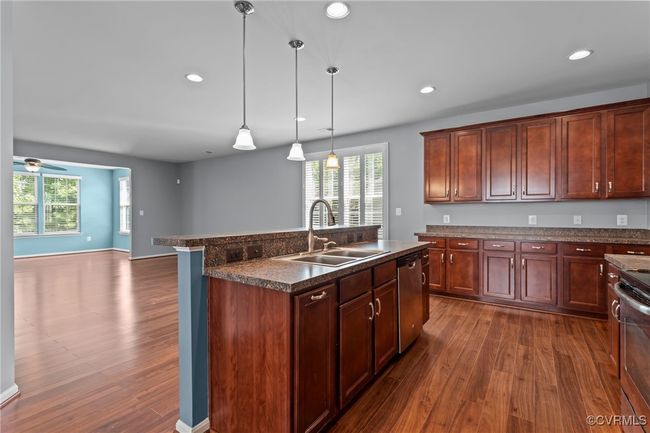 Kitchen with dark countertops, dark wood finished floors, healthy amount of natural light, stainless steel dishwasher, and recessed lighting | Image 7