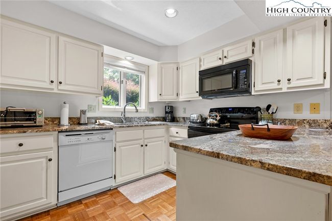 Kitchen has pretty granite counters light cabinets | Image 7
