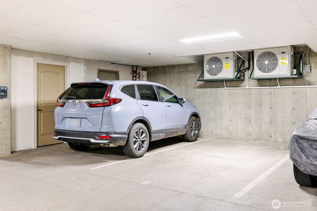 Two secure parking spots with a storage room to the left. | Image 29
