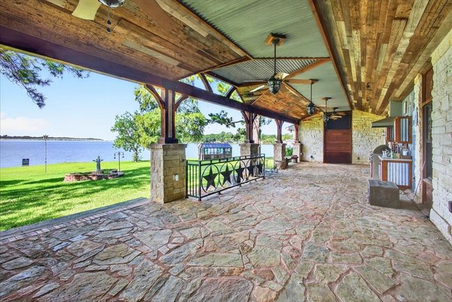 View of patio / terrace with a ceiling fan and a water view | Image 13