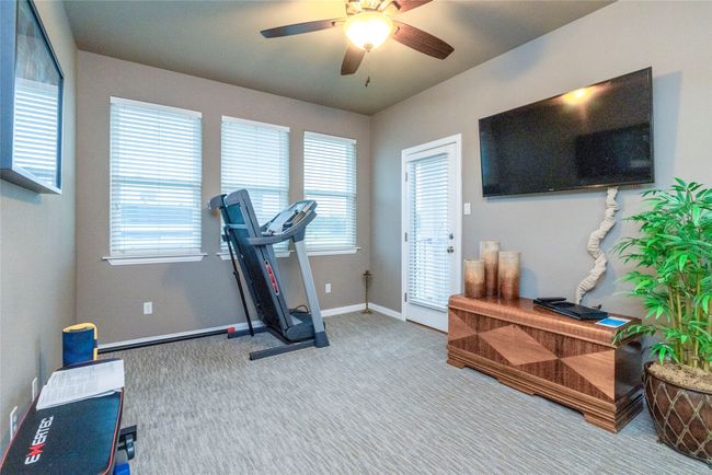 Secondary bedroom being used as a workout area featuring an exit to the balcony with views of the golf course. | Image 28