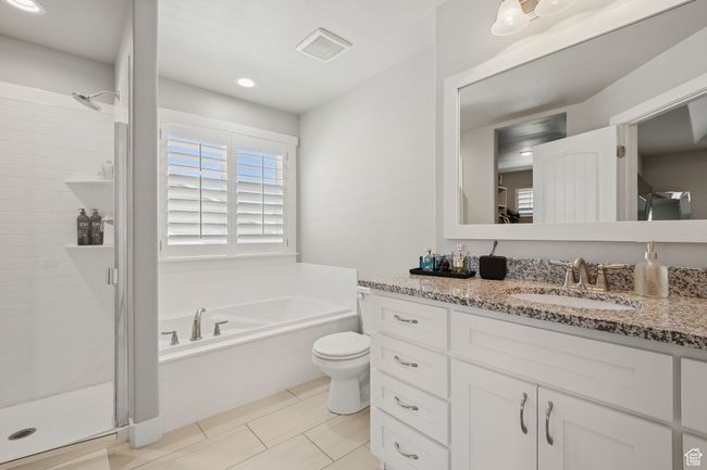 Full bathroom with vanity, a garden tub, a stall shower, and tile patterned floors | Image 20