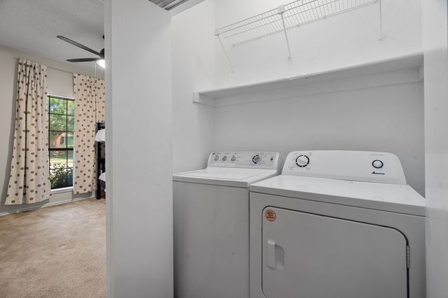 Laundry room with separate washer and dryer, light carpet, and ceiling fan | Image 19